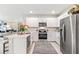 Bright kitchen with stainless steel appliances, white cabinets, and a view into the living area at 16408 Bridle Ridge St, Port Charlotte, FL 33953