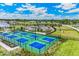 Scenic aerial view of the community's pickleball courts set amongst the manicured green spaces and lush landscaping at 16408 Bridle Ridge St, Port Charlotte, FL 33953