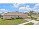 Single-story home featuring a terracotta roof, attached two-car garage, brick driveway, and manicured landscaping at 1715 Queen Palm Way, North Port, FL 34288