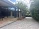 The pavers are surrounded by palm trees and a view of the screened in lanai and pool at 2031 Basin St, Port Charlotte, FL 33952