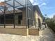 Paver backyard area with an outdoor kitchen and screened-in patio at 2031 Basin St, Port Charlotte, FL 33952