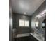 Bathroom featuring a stylish dual sink vanity, tiled bathtub, and modern lighting fixtures at 2031 Basin St, Port Charlotte, FL 33952