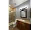 Bathroom featuring a single sink vanity, decorative mirror, and glass shower at 2031 Basin St, Port Charlotte, FL 33952