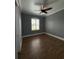 Bedroom with stylish wood-look tile flooring, neutral paint, and a view through the window at 2031 Basin St, Port Charlotte, FL 33952