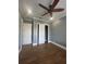 Bedroom with wood-look tile flooring, neutral paint, and double door closet with storage at 2031 Basin St, Port Charlotte, FL 33952