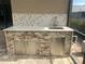 Outdoor kitchen features a stone base, mosaic backsplash, stainless steel appliances, and sink at 2031 Basin St, Port Charlotte, FL 33952