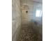 Walk-in shower boasting pebble tile flooring, a wood-look tile surround and a niche at 2031 Basin St, Port Charlotte, FL 33952