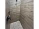 Modern shower with wood-look tile and pebble stone flooring at 2031 Basin St, Port Charlotte, FL 33952
