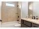 Well-lit bathroom featuring a shower-tub combo with neutral tile and a granite-topped vanity with dark cabinetry at 23218 Fawn Ave, Punta Gorda, FL 33980