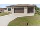 Charming single-story home featuring a spacious three-car garage and well-manicured lawn, illuminated for daytime appeal at 23218 Fawn Ave, Punta Gorda, FL 33980