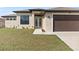 Charming single-story home featuring a spacious three-car garage and well-manicured lawn, illuminated for daytime appeal at 23218 Fawn Ave, Punta Gorda, FL 33980