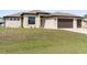 Charming single-story home featuring a spacious three-car garage and well-manicured lawn, illuminated for daytime appeal at 23218 Fawn Ave, Punta Gorda, FL 33980