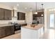 Modern kitchen with stainless steel appliances, granite countertops, island with pendant lighting, and sleek dark cabinetry at 23218 Fawn Ave, Punta Gorda, FL 33980