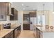Modern kitchen with stainless steel appliances, granite countertops, island with pendant lighting, and sleek dark cabinetry at 23218 Fawn Ave, Punta Gorda, FL 33980