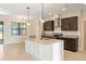 Bright kitchen featuring a large center island, granite countertops, stainless steel appliances, and modern lighting at 23218 Fawn Ave, Punta Gorda, FL 33980