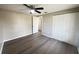 This bedroom features a ceiling fan, modern gray flooring, and a convenient closet for ample storage space at 2507 Linton Ln, Port Charlotte, FL 33952