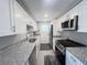 Well-lit, updated kitchen boasting granite countertops, stainless steel appliances, and white cabinets at 2507 Linton Ln, Port Charlotte, FL 33952