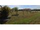Expansive backyard with a partial fence, featuring scattered vegetation and sunlight, offers a serene outdoor setting at 30035 Alder Rd, Punta Gorda, FL 33982