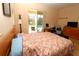 Comfortable bedroom with access to the lanai and views of the pool at 30035 Alder Rd, Punta Gorda, FL 33982