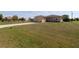Sprawling lawn leads to a single-story home with an attached garage on a sunny day, promising ample outdoor space at 30035 Alder Rd, Punta Gorda, FL 33982