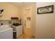Laundry room featuring modern appliances, ample shelving, and tiled flooring at 30035 Alder Rd, Punta Gorda, FL 33982