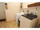 Laundry area with modern washer and dryer set, shelving, and tiled floor at 30035 Alder Rd, Punta Gorda, FL 33982