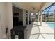 Covered patio with an adjacent pool, outdoor seating and ceiling fan at 30035 Alder Rd, Punta Gorda, FL 33982