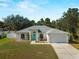 Charming single-story home featuring a blue front door, well-manicured lawn and attached two-car garage at 3213 Belleville Ter, North Port, FL 34286