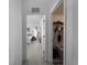 Hallway view featuring a bedroom with a white comforter and a closet with ample storage space at 3213 Belleville Ter, North Port, FL 34286
