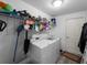 Efficient laundry room with washer, dryer, shelving, and white walls at 3213 Belleville Ter, North Port, FL 34286