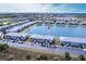 An aerial view of lakeside condos and parking area, with a backdrop of lush greenery and community amenities at 3310 Loveland Blvd # 1808, Punta Gorda, FL 33980