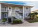A closer exterior view shows the stairs to the second floor, with some manicured bushes at 3310 Loveland Blvd # 1808, Punta Gorda, FL 33980