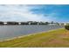 Expansive pond view showcases waterfront condos, set against a clear blue sky and lush landscaping at 3310 Loveland Blvd # 1808, Punta Gorda, FL 33980