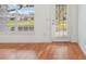 Bright living room features wood floors, a large window and a white front door with blinds at 3391 Rogue St, North Port, FL 34291