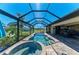 Outdoor screened-in pool and spa feature stone pavers with plenty of seating and a golf course view at 3620 Carmichael Dr, Punta Gorda, FL 33950