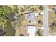 An aerial view of a waterfront property featuring a boat lift, screened-in patio, and adjacent tennis court at 3627 Easy St, Port Charlotte, FL 33952