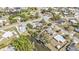 Aerial view of neighborhood homes, a canal with boat dock, and palm trees on expansive lawns at 3627 Easy St, Port Charlotte, FL 33952