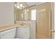 Bathroom features glass-enclosed shower, neutral-toned tiles, and sink with large mirror at 3627 Easy St, Port Charlotte, FL 33952
