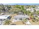 Aerial view of a cozy single-story home that has a backyard canal, screened in patio, and tropical landscaping at 3627 Easy St, Port Charlotte, FL 33952