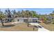Charming single-story home with a well-maintained lawn, carport, and lush trees at 3627 Easy St, Port Charlotte, FL 33952