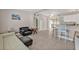Open-concept living area featuring tile flooring, bar seating, and access to the sunroom at 3627 Easy St, Port Charlotte, FL 33952