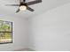 Bedroom with ceiling fan, wood-look tile flooring and a view of trees from a window at 3700 Bobko Cir, North Port, FL 34291