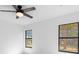 Bedroom with ceiling fan, wood-look tile flooring and two windows letting in natural light at 3700 Bobko Cir, North Port, FL 34291