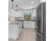 Bright kitchen with white cabinets, stainless steel appliances, an island with granite countertop, and modern lighting at 3700 Bobko Cir, North Port, FL 34291