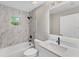 Bathroom featuring a tub, shower with rainfall showerhead, updated vanity, and marble-look shower surround at 3841 Cinderella Rd, North Port, FL 34286