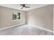A bright empty bedroom with a ceiling fan and a large window at 3841 Cinderella Rd, North Port, FL 34286