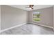 A bright empty bedroom with a ceiling fan and a large window at 3841 Cinderella Rd, North Port, FL 34286