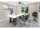 Modern home office with a bright window, a desk with two chairs, and potted plants at 3841 Cinderella Rd, North Port, FL 34286