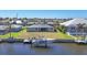 Aerial view of home and backyard with boat on lift at the canal, surrounded by landscaping and other homes at 430 Capri Isles Ct, Punta Gorda, FL 33950