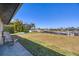Large grass backyard with view of canal and boat docks, plus patio with Adirondack chairs at 430 Capri Isles Ct, Punta Gorda, FL 33950